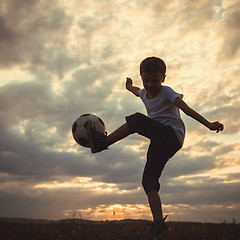 Image showing Young little boy playing in the field  with soccer ball.