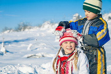 Image showing Happy little children playing  in winter snow day.