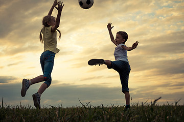 Image showing Happy young little boy and girl playing in the field  with socce