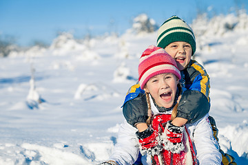 Image showing Happy little children playing  in winter snow day.