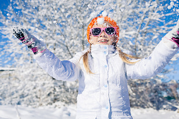 Image showing Happy little girl playing  on winter snow day.