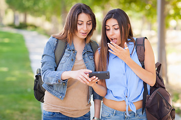 Image showing Two Beautiful Young Ethnic Twin Sisters With Backpacks Using A S