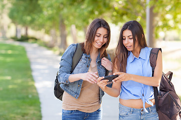 Image showing Two Beautiful Young Ethnic Twin Sisters With Backpacks Using A S