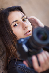 Image showing Young Adult Ethnic Female Photographer Against Wall Holding Came