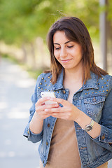 Image showing Beautiful Young Ethnic Woman Using Her Smartphone Outside.