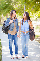 Image showing Two Beautiful Young Ethnic Twin Sisters With Backpacks Walking O