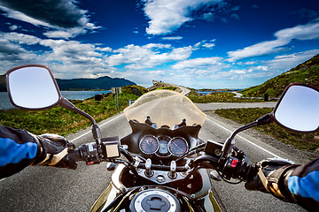 Image showing Biker rides a road with Atlantic Ocean Road in Norway. First-per