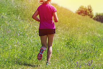 Image showing Young Woman running marathon outdoors in sunset