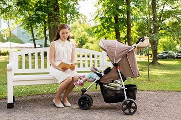 Image showing mother with child in stroller reading book at park