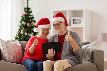 Image showing happy senior couple with tablet pc at christmas