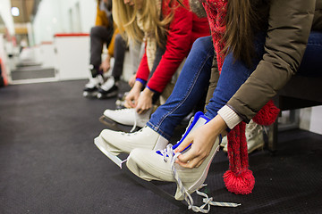 Image showing close up of woman putting on ice skates