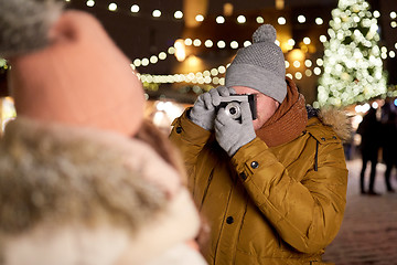 Image showing man with camera photographing woman at christmas