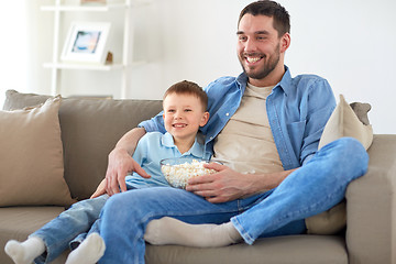 Image showing father and son with popcorn watching tv at home