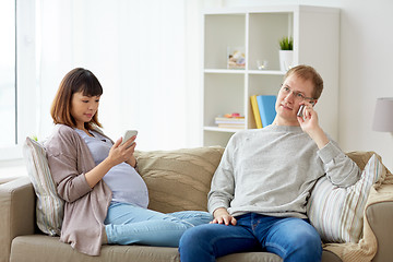 Image showing husband and pregnant wife with smartphone at home