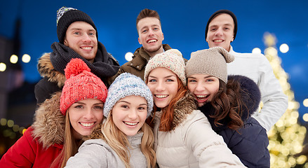 Image showing happy friends taking selfie outdoors at christmas