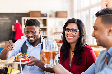 Image showing happy friends eating at restaurant