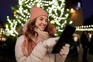 Image showing woman with tablet pc at christmas tree outdoors