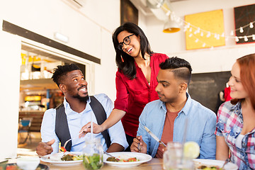 Image showing happy friends eating at restaurant