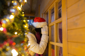 Image showing woman looking to house window at christmas market