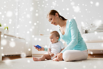 Image showing happy mother showing smartphone to baby at home