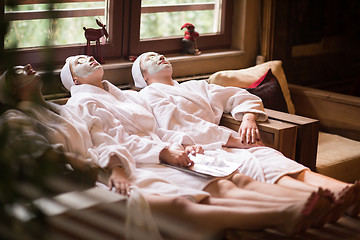 Image showing women is getting facial clay mask at spa