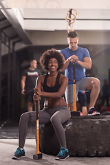 Image showing multiethnic couple after workout with hammer