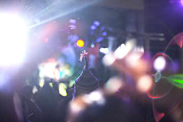 Image showing The silhouettes of concert crowd in front of bright stage lights