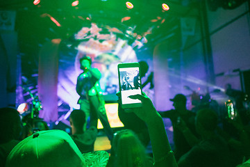 Image showing The silhouettes of concert crowd in front of bright stage lights