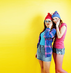 Image showing lifestyle people concept: two pretty young school teenage girls having fun happy smiling on yellow background