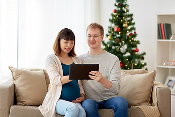 Image showing man and pregnant wife with tablet pc at christmas