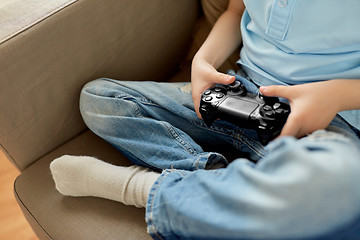 Image showing little boy with gamepad playing video game at home