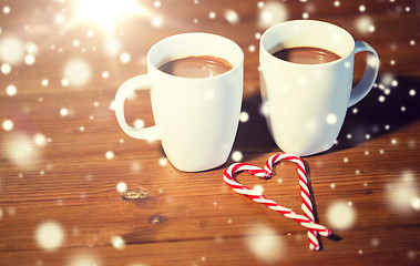 Image showing christmas candy canes and cups on wooden table