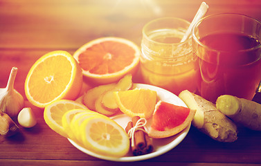 Image showing ginger tea with honey, citrus and garlic on wood