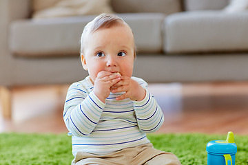 Image showing baby boy on floor and eating rice cracker at home