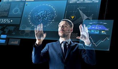 Image showing businessman with virtual projection over black