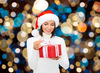 Image showing smiling woman in santa hat with christmas gift