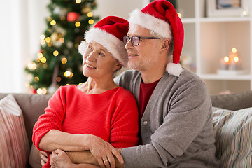 Image showing happy senior couple in santa hats at christmas