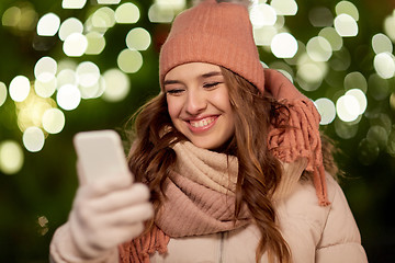 Image showing happy woman with smartphone at christmas
