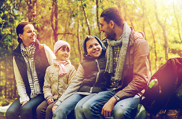 Image showing happy family sitting on bench and talking at camp