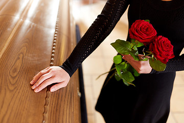 Image showing woman with red roses and coffin at funeral