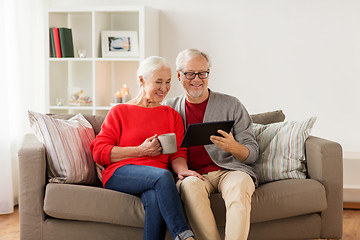 Image showing happy senior couple with tablet pc at christmas