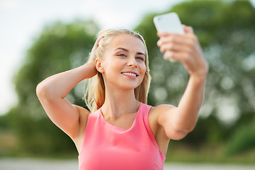 Image showing happy woman taking selfie with smartphone outdoors