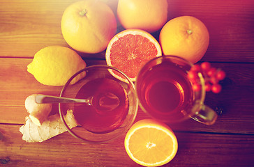 Image showing ginger tea with honey, citrus and garlic on wood