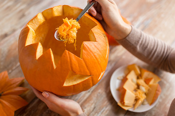 Image showing close up of woman carving halloween pumpkin