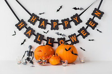 Image showing carved pumpkins with candies and halloween garland