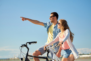 Image showing happy young couple riding bicycles at seaside