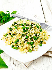 Image showing Couscous with spinach in plate on board