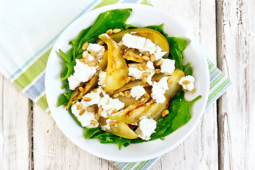 Image showing Salad from pear and spinach in dish on light board top