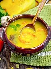 Image showing Soup-puree pumpkin with prawns and champignons on dark board