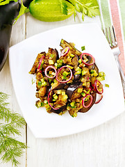 Image showing Salad from eggplant and cucumber in plate on board top